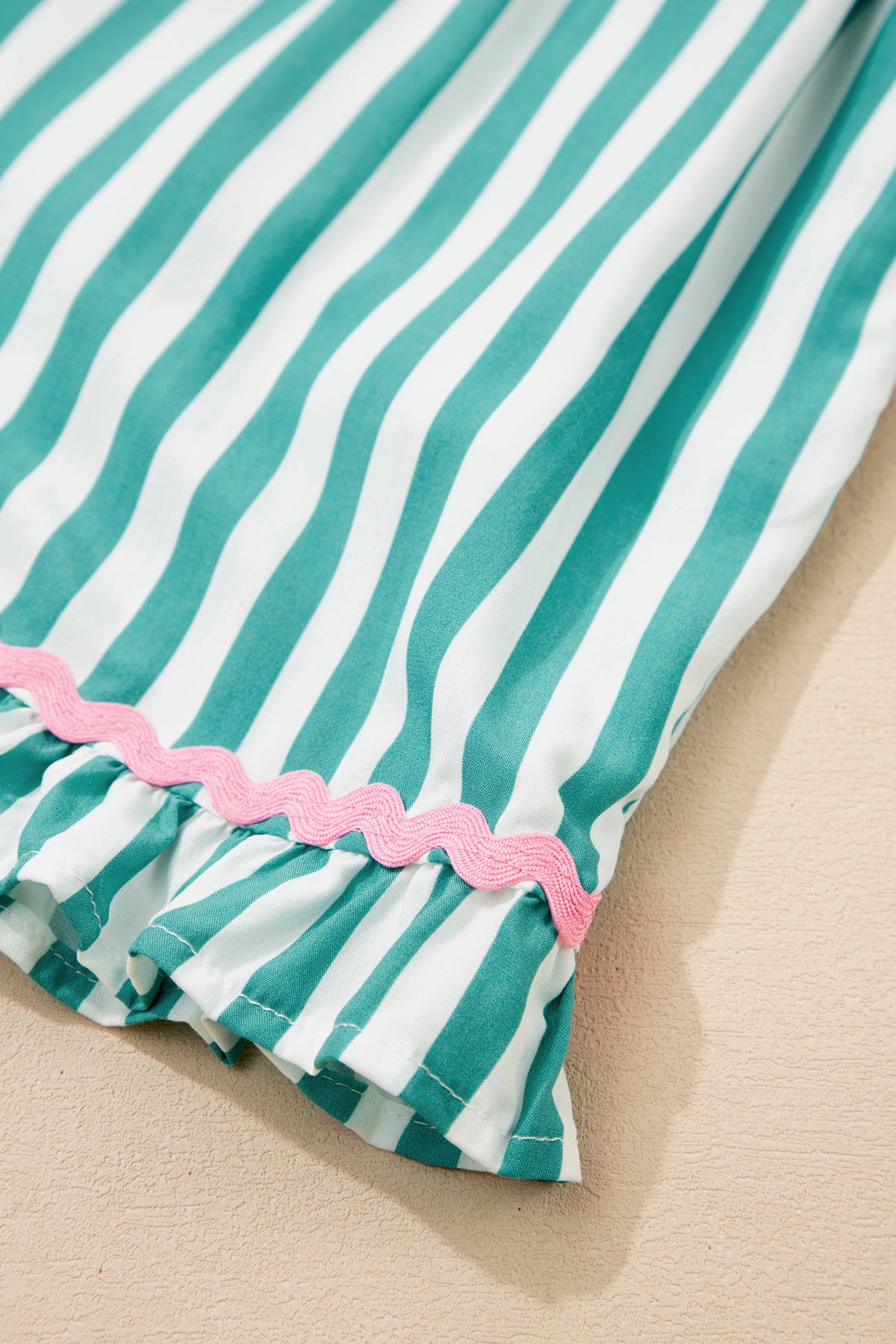 Conjunto de pijama corto con camisa de manga larga, cordón ajustable y ribete de ricrac en contraste y rayas verdes.