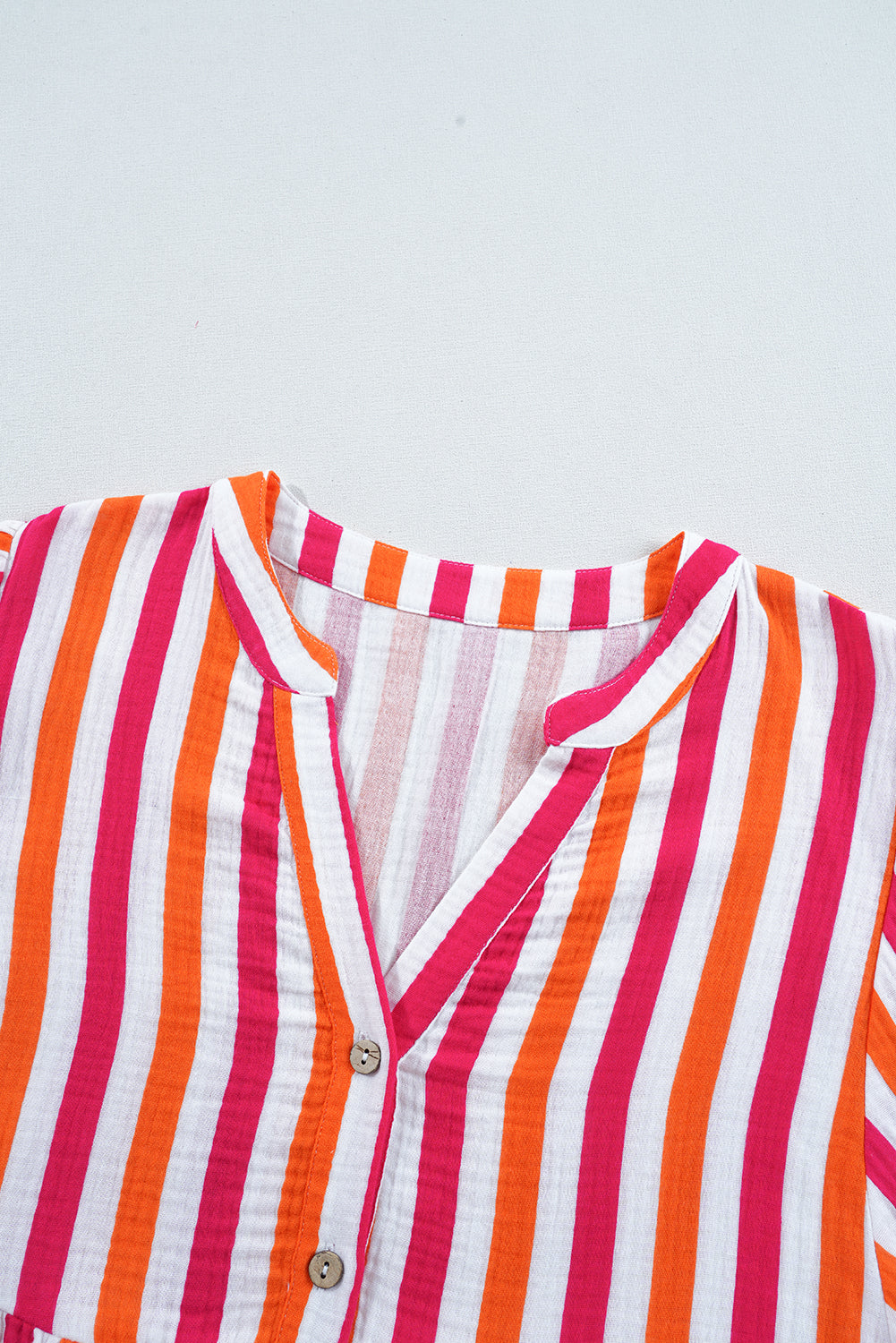 Blusa de manga abullonada con escote en V y botones delanteros, de rayas naranjas.