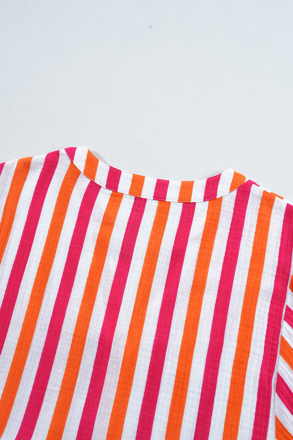 Blusa de manga abullonada con escote en V y botones delanteros, de rayas naranjas.