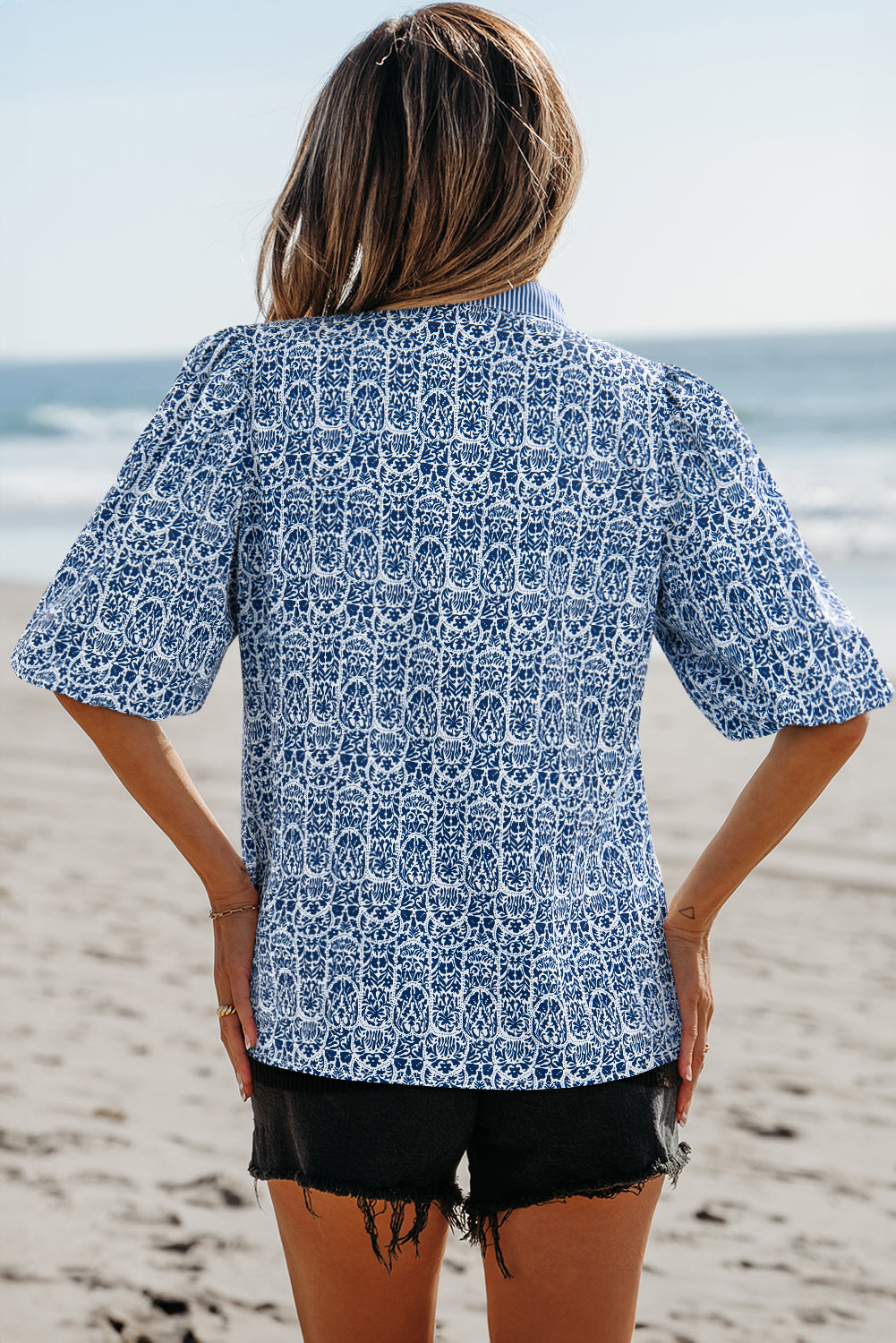 Top de manga abullonada con estampado floral azul y rayas en contraste.