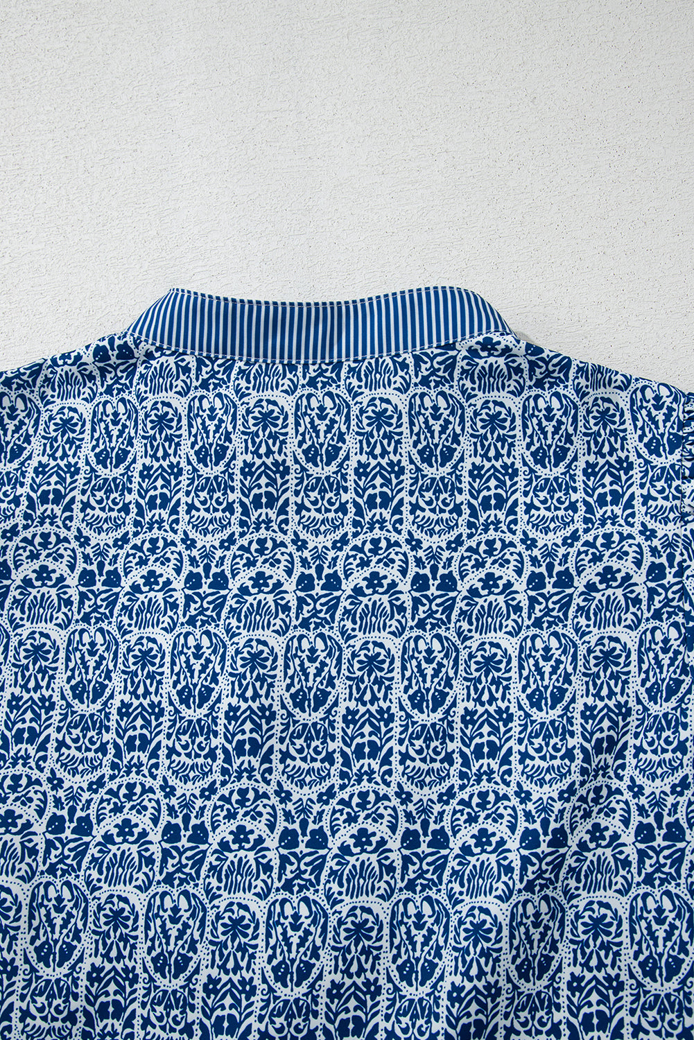 Top de manga abullonada con estampado floral azul y rayas en contraste.