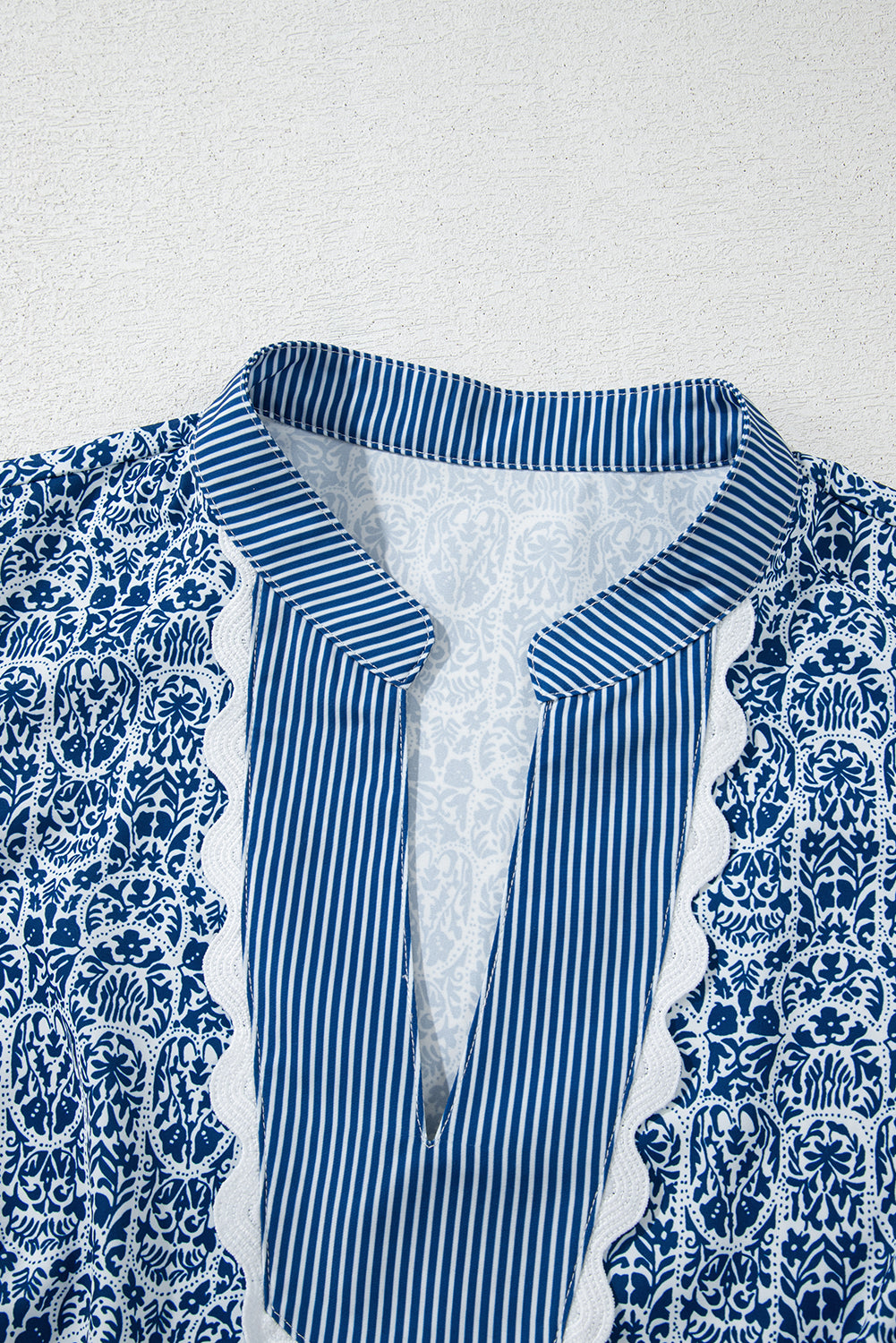 Top de manga abullonada con estampado floral azul y rayas en contraste.