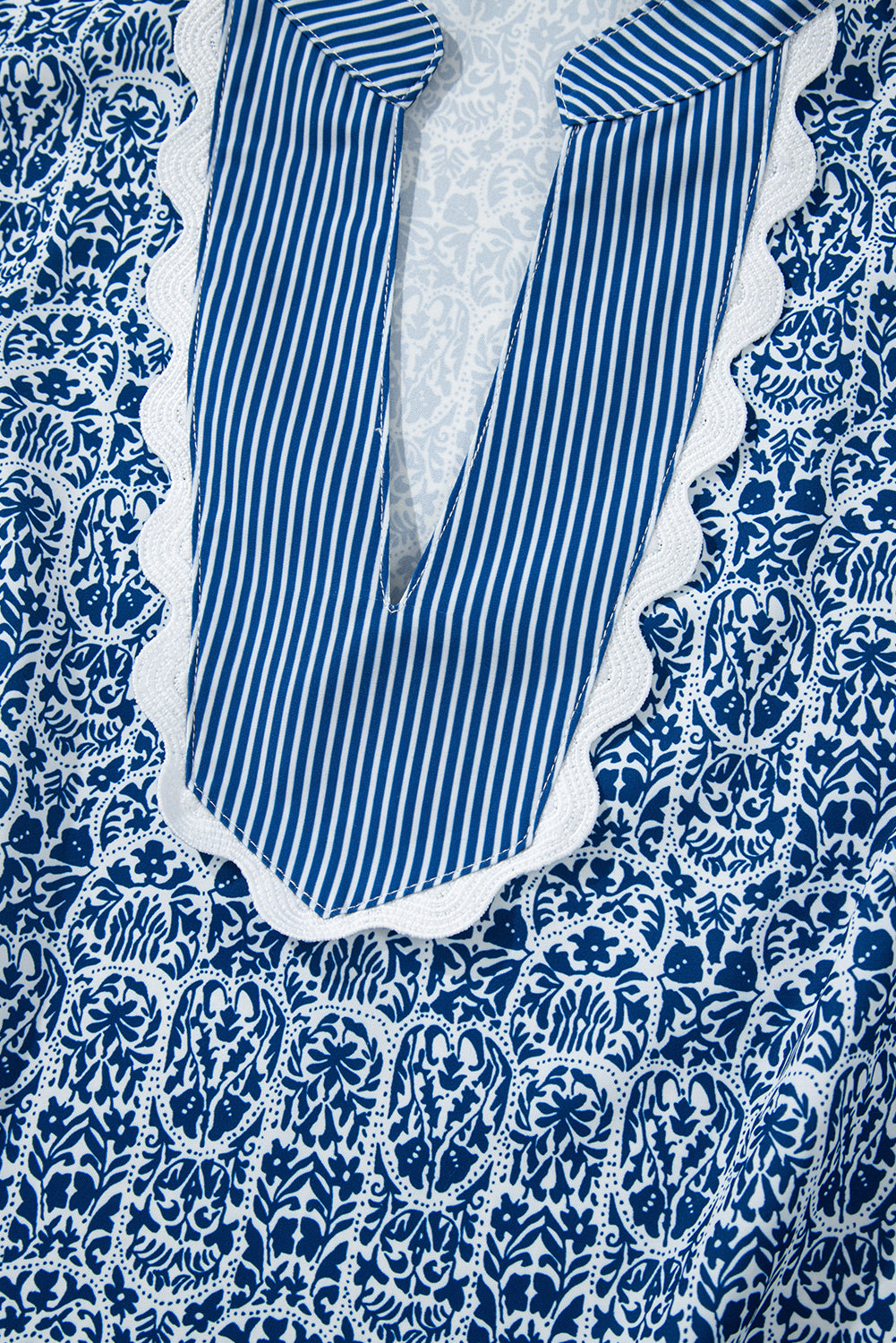 Top de manga abullonada con estampado floral azul y rayas en contraste.
