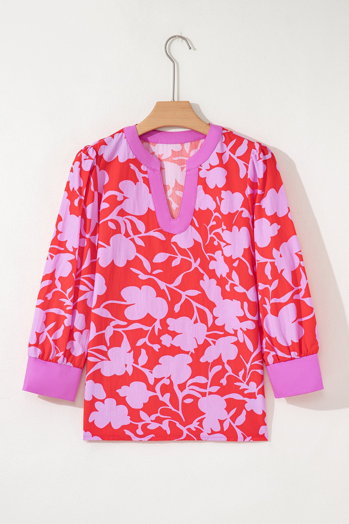 Blusa roja con estampado floral, escote en V dividido y mangas tipo brazalete con puños.