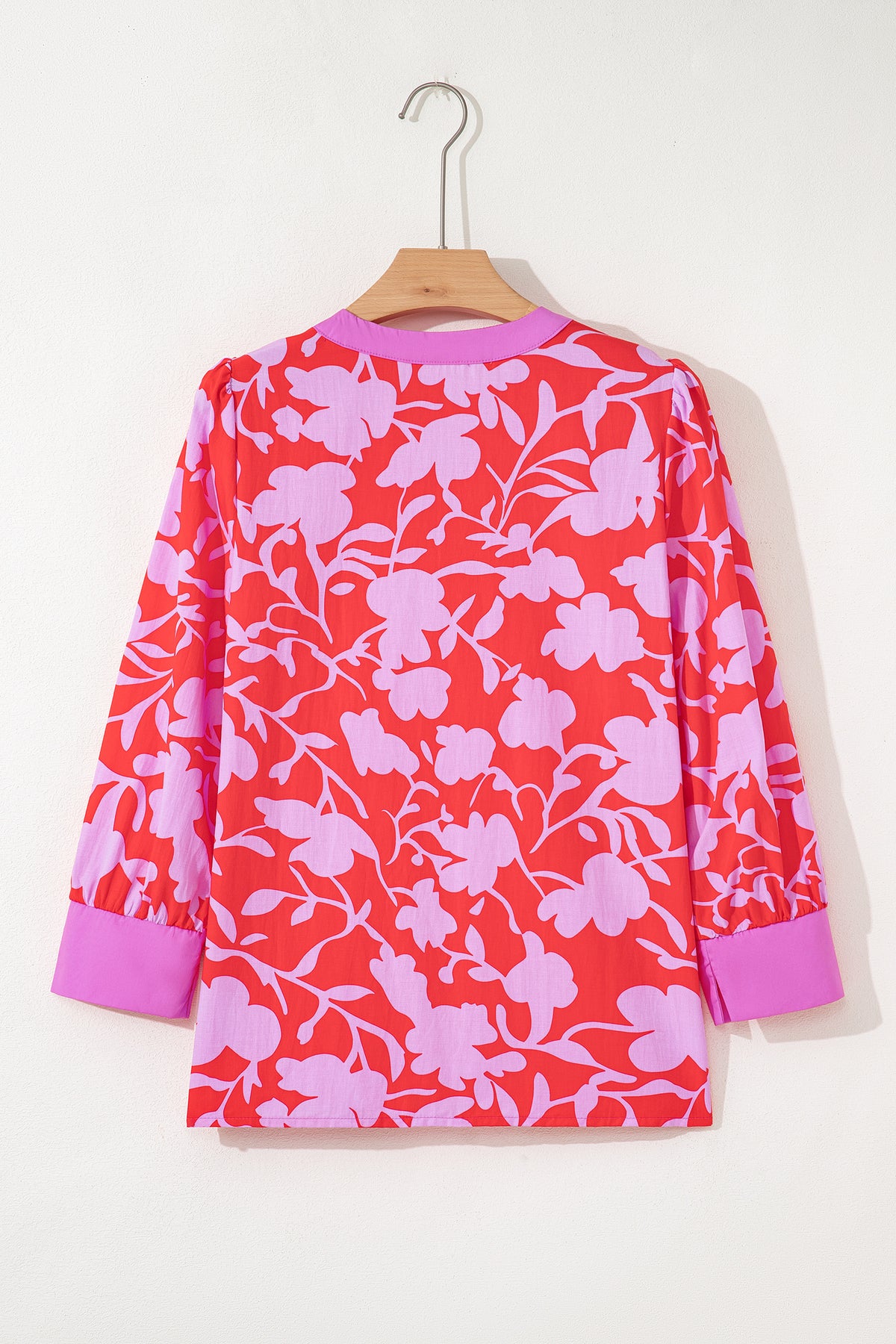 Blusa roja con estampado floral, escote en V dividido y mangas tipo brazalete con puños.
