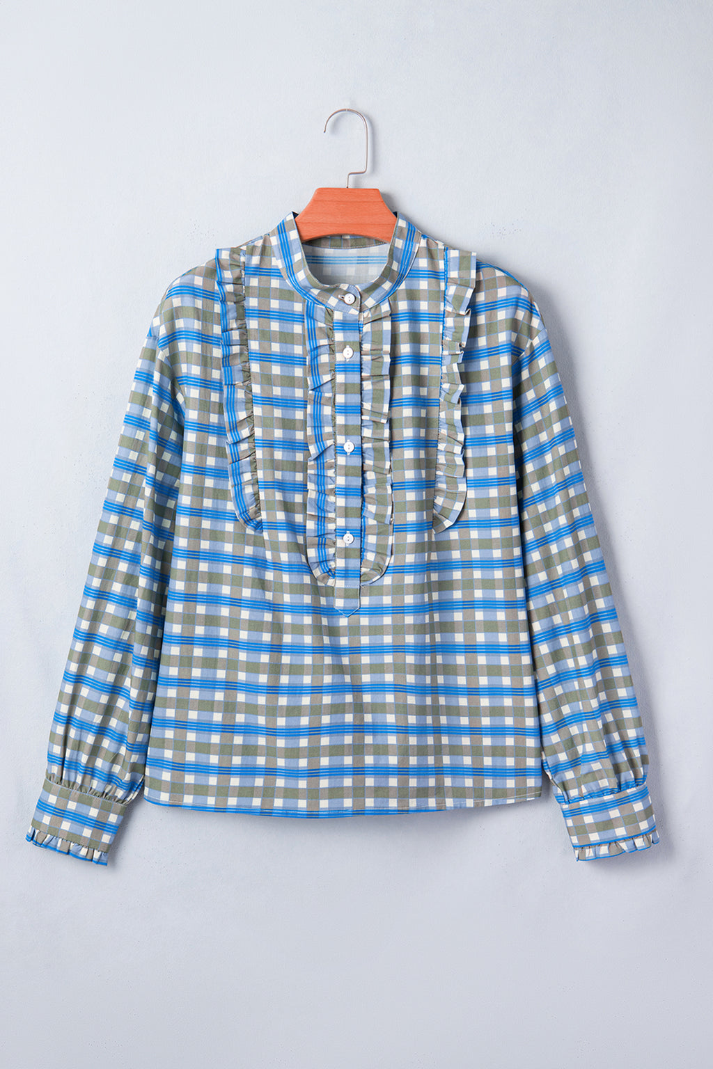 Blusa de manga larga a cuadros azul cielo con detalle de volantes y medio botón.