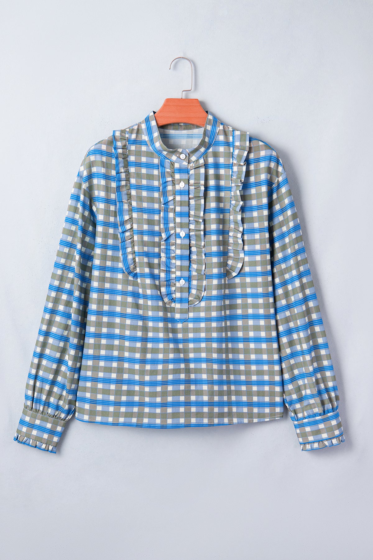 Blusa de manga larga a cuadros azul cielo con detalle de volantes y medio botón.