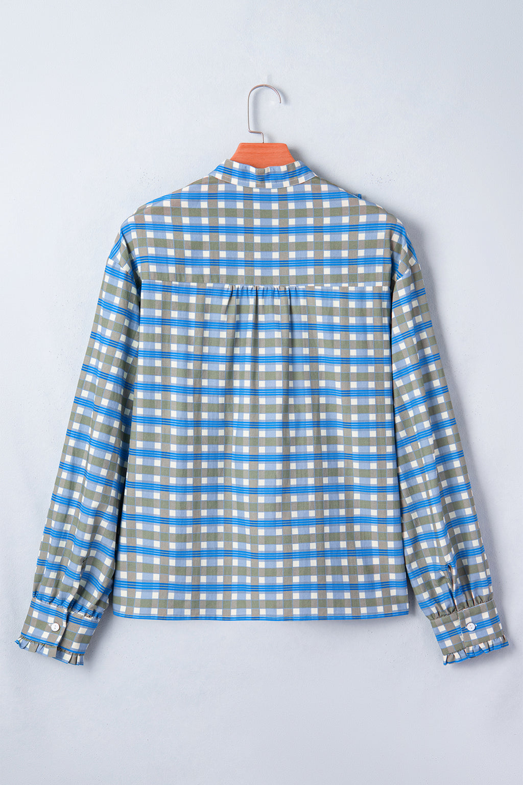 Blusa de manga larga a cuadros azul cielo con detalle de volantes y medio botón.