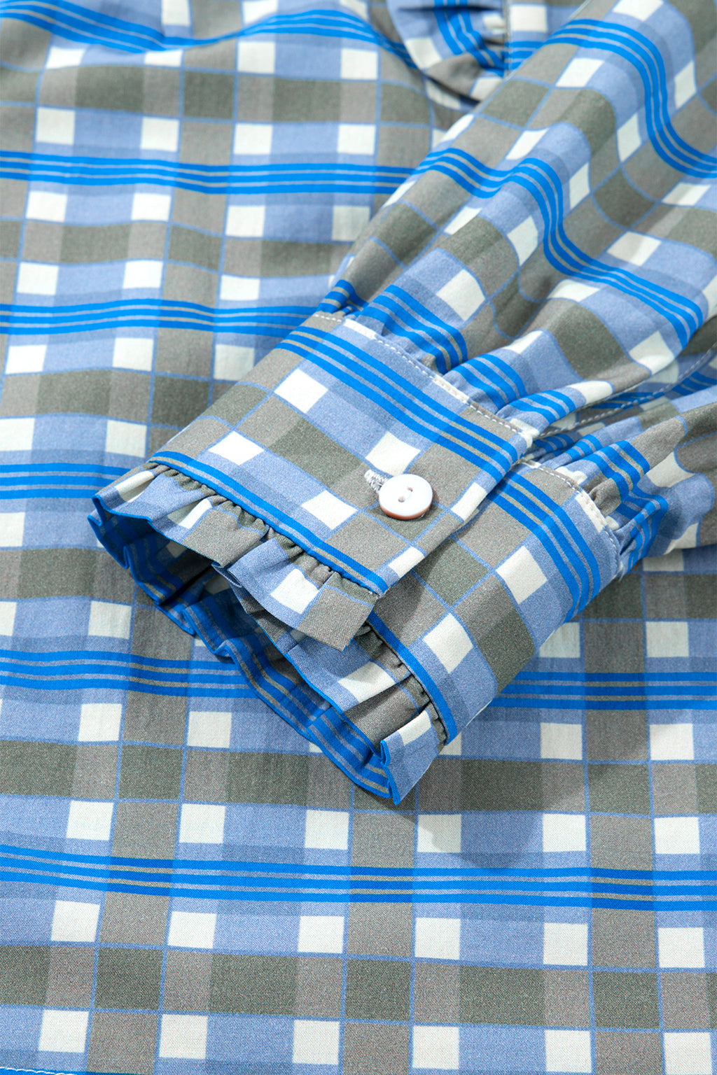 Blusa de manga larga a cuadros azul cielo con detalle de volantes y medio botón.