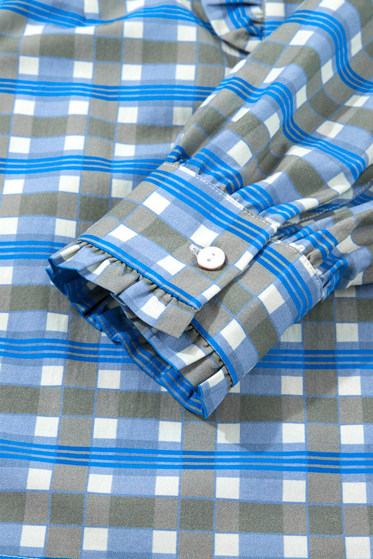Blusa de manga larga a cuadros azul cielo con detalle de volantes y medio botón.
