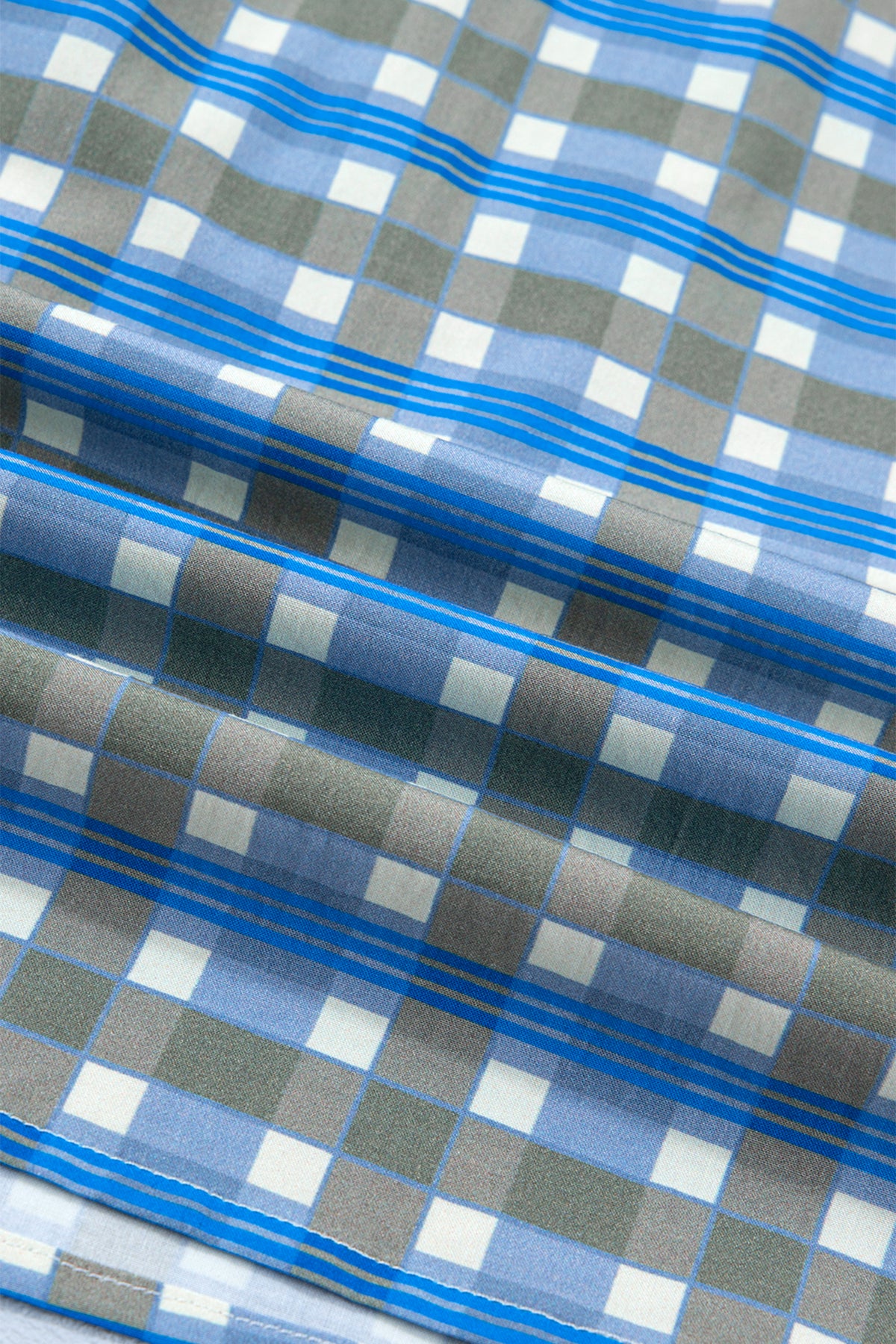 Blusa de manga larga a cuadros azul cielo con detalle de volantes y medio botón.