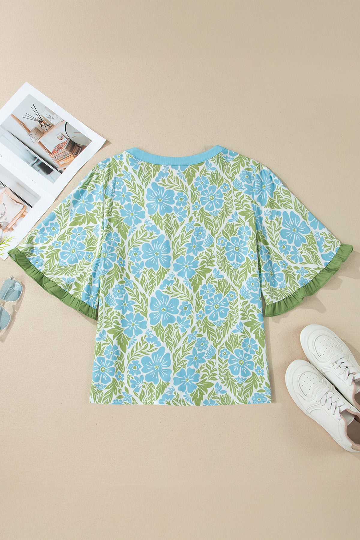 Blusa de manga corta con volantes y ribete de bloques de color, estampado floral azul cielo.