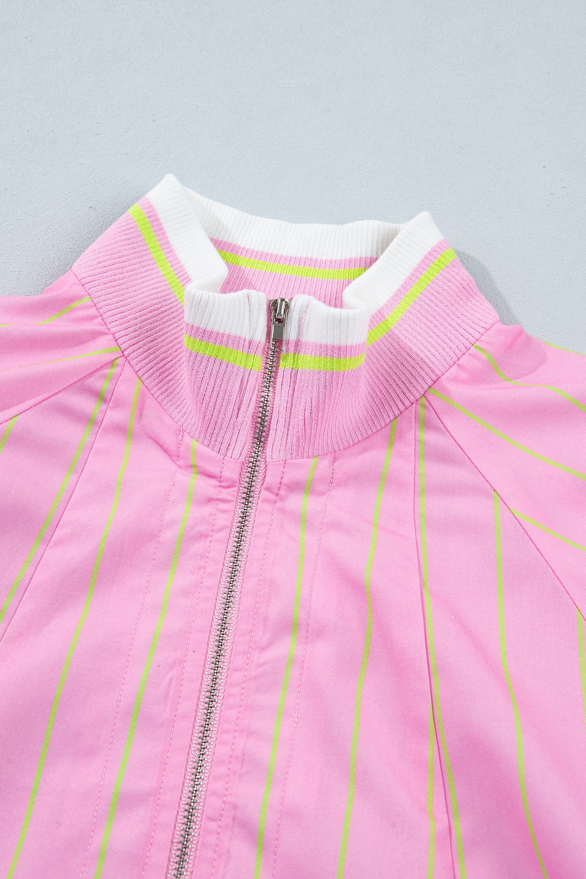 Blusa informal de corte recto con cuello en V, mangas cortas, cremallera y puños acanalados, de rayas rosas.