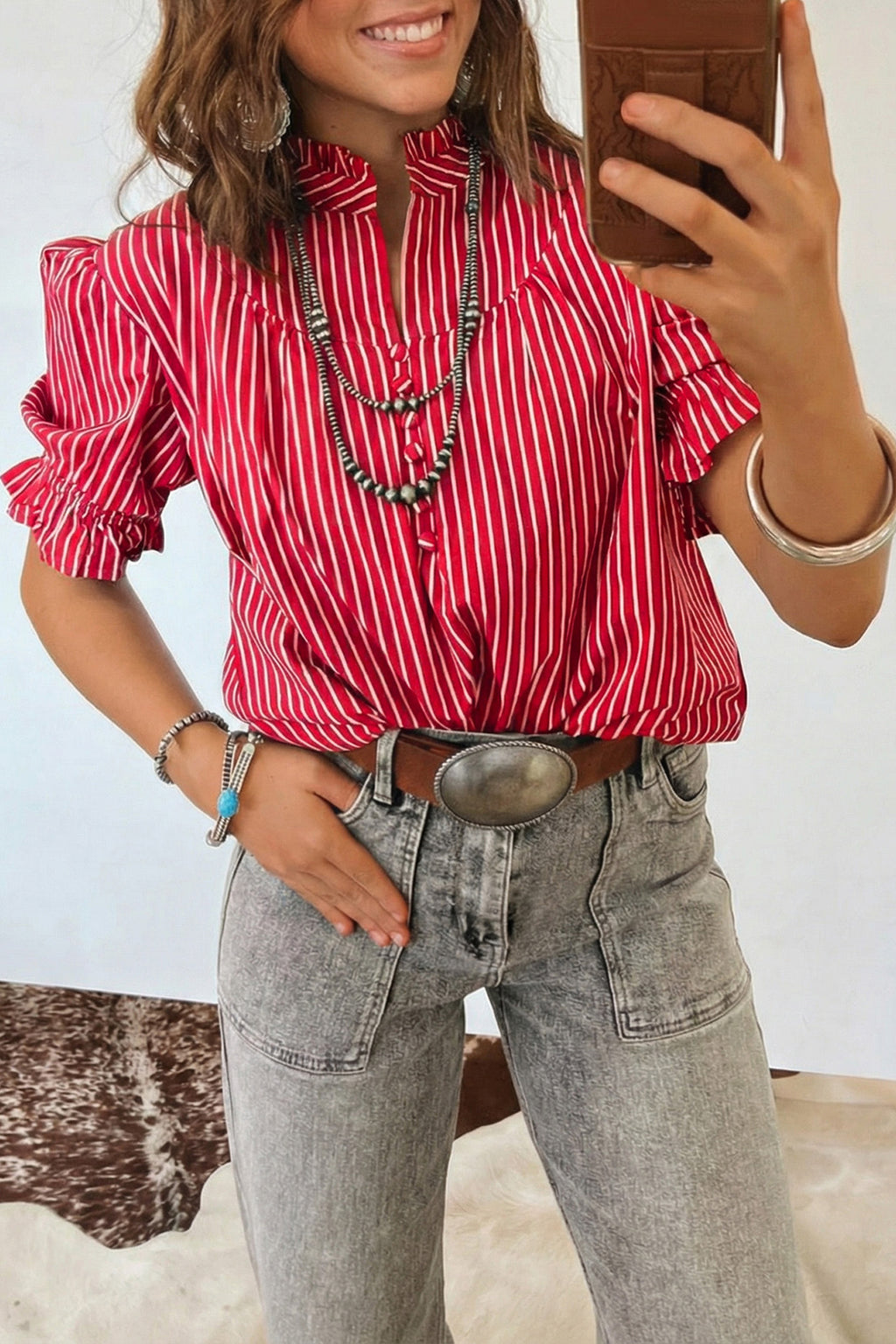 Blusa de manga corta abullonada con volantes y rayas azules, con botones en la parte delantera.