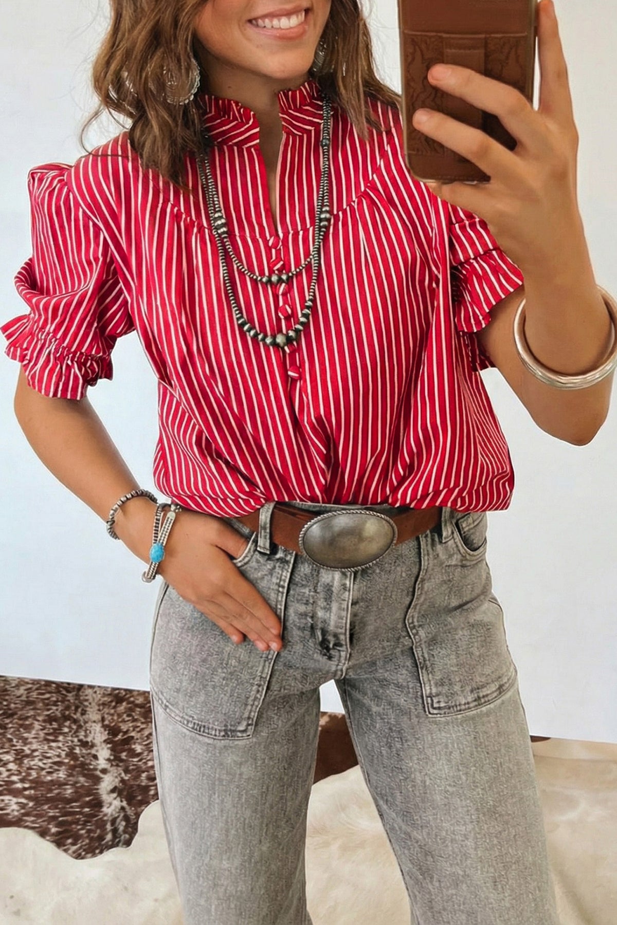 Blusa de manga corta abullonada con volantes y rayas azules, con botones en la parte delantera.