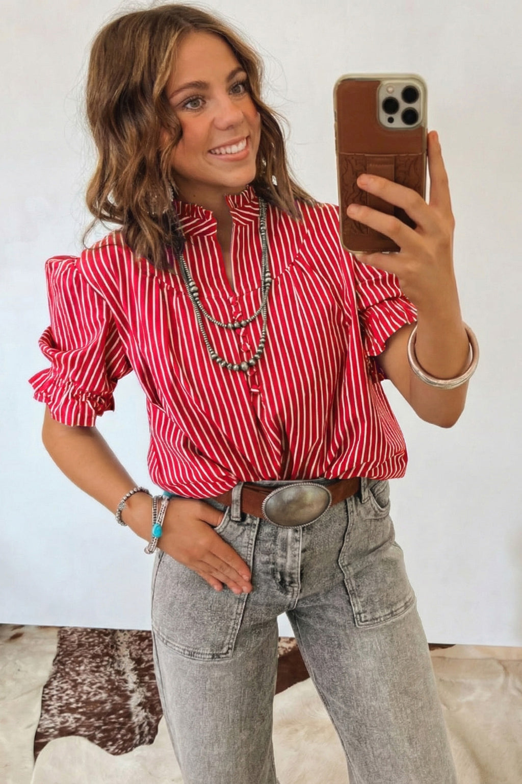 Blusa de manga corta abullonada con volantes y rayas azules, con botones en la parte delantera.
