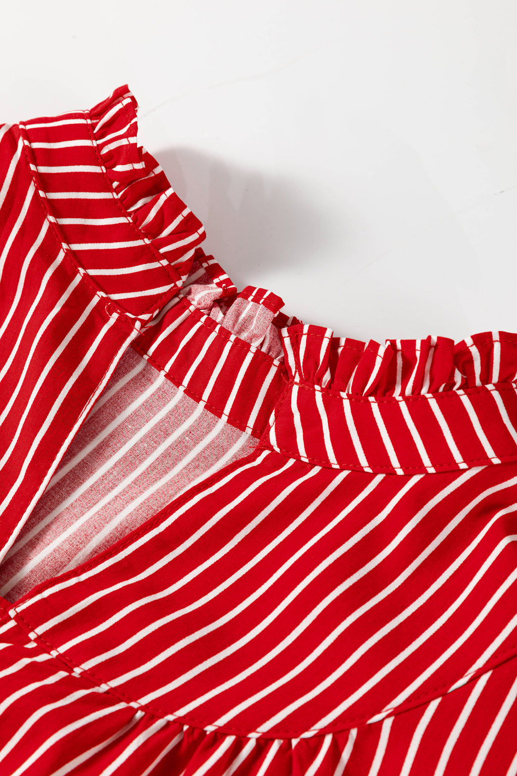 Blusa de manga corta abullonada con volantes y rayas azules, con botones en la parte delantera.