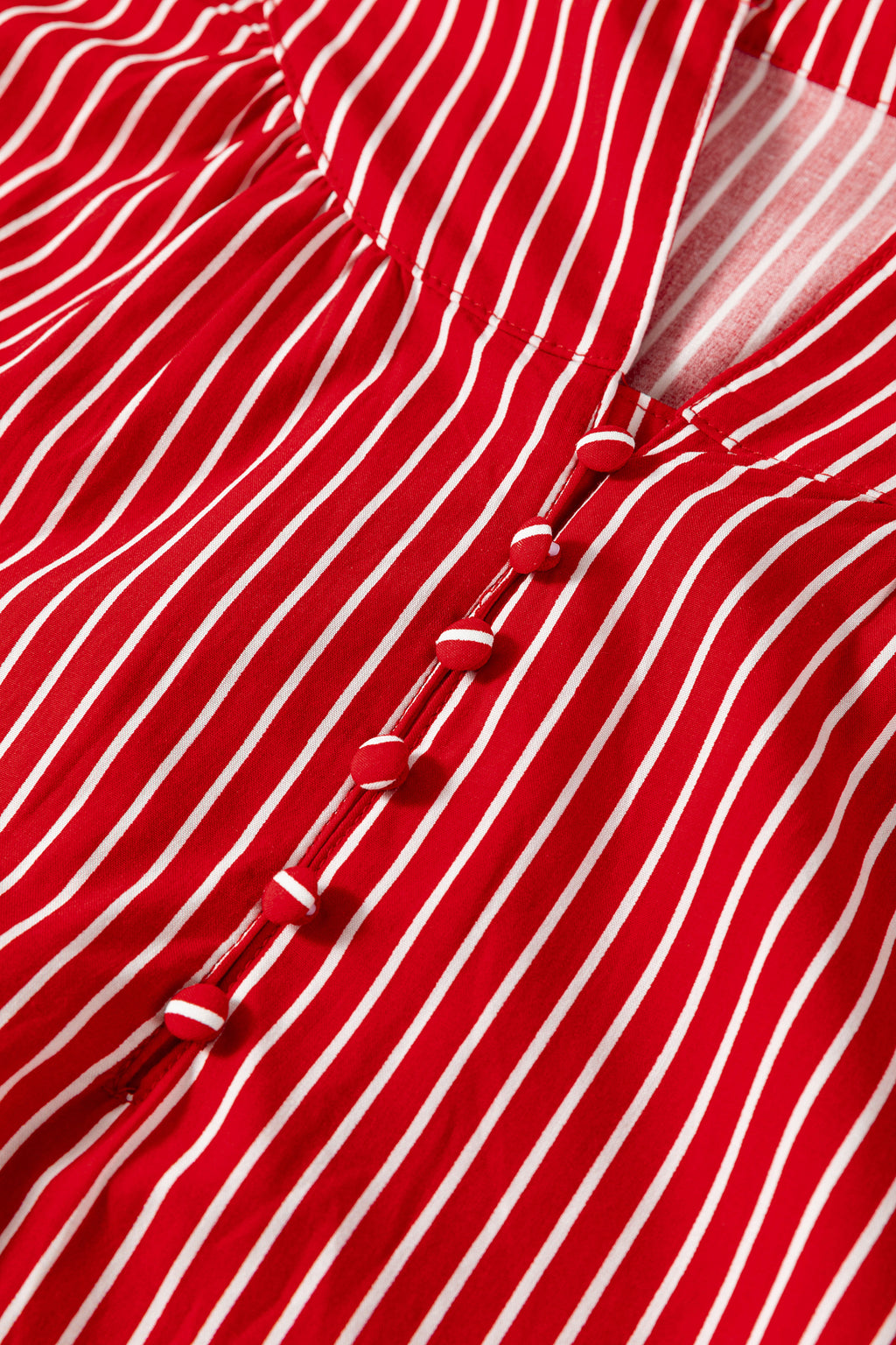 Blusa de manga corta abullonada con volantes y rayas azules, con botones en la parte delantera.