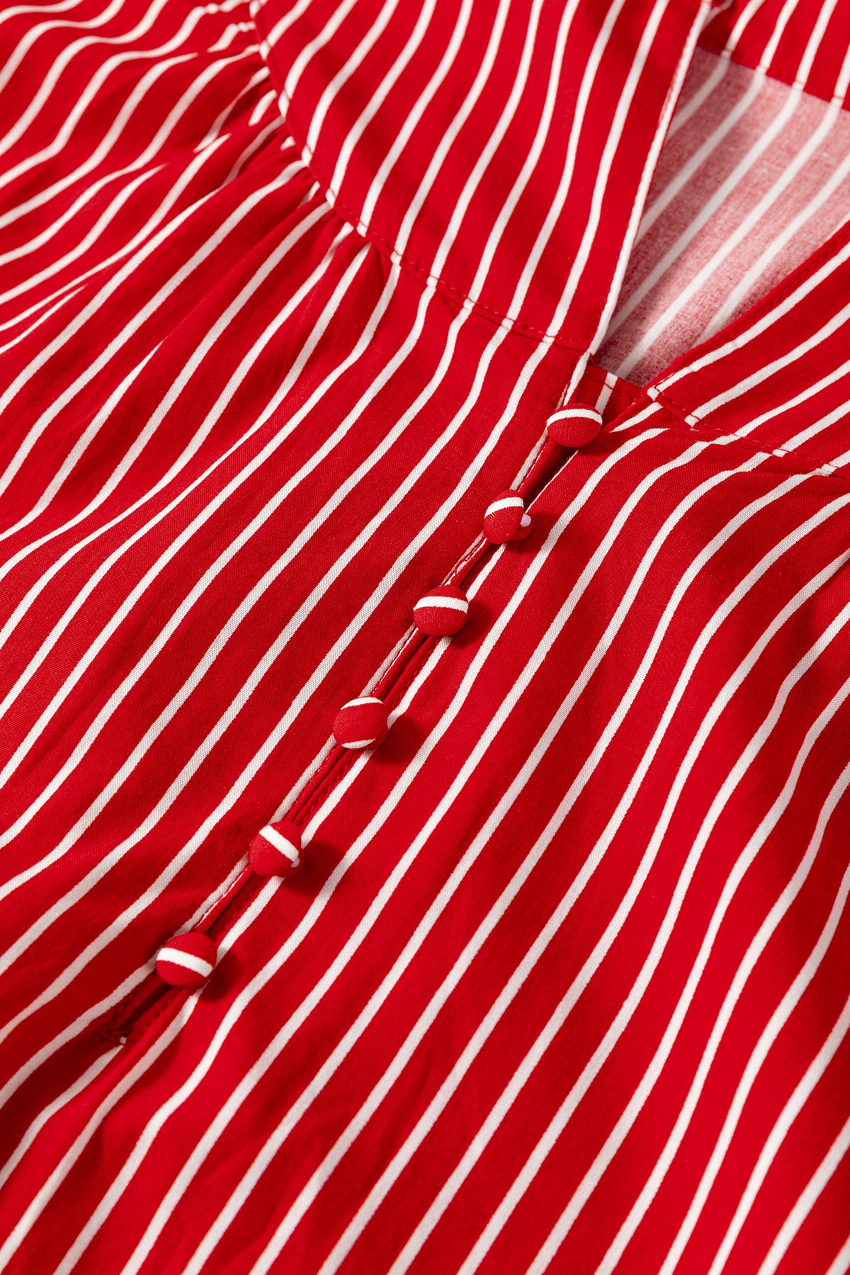 Blusa de manga corta abullonada con volantes y rayas azules, con botones en la parte delantera.