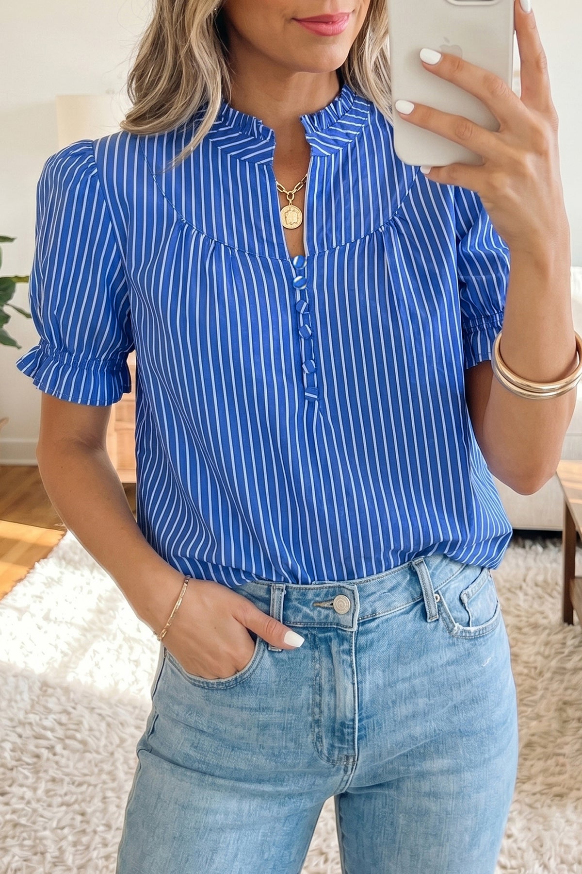 Blusa de manga corta abullonada con volantes y rayas azules, con botones en la parte delantera.