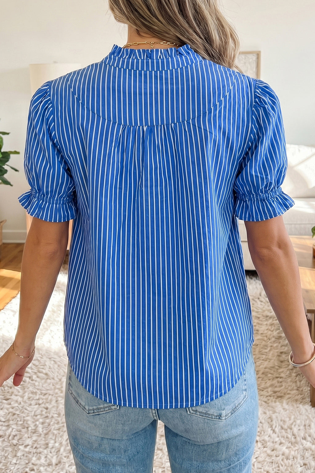 Blusa de manga corta abullonada con volantes y rayas azules, con botones en la parte delantera.