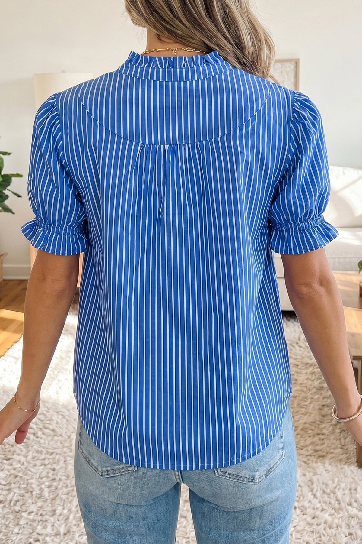 Blusa de manga corta abullonada con volantes y rayas azules, con botones en la parte delantera.