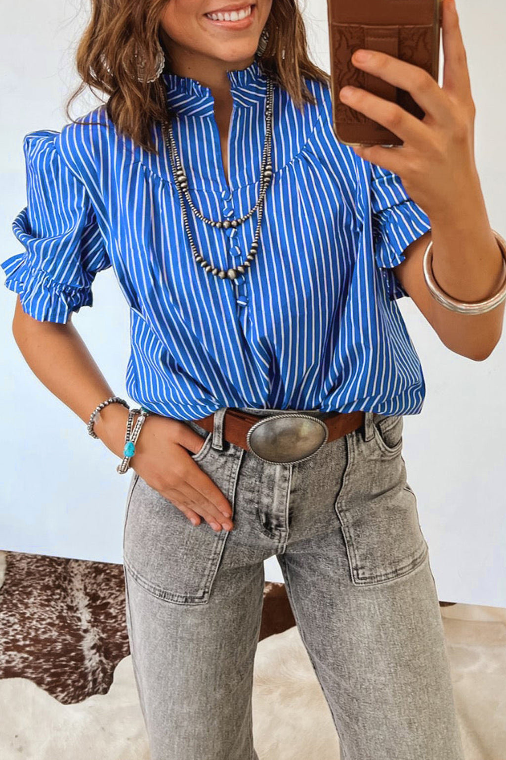 Blusa de manga corta abullonada con volantes y rayas azules, con botones en la parte delantera.