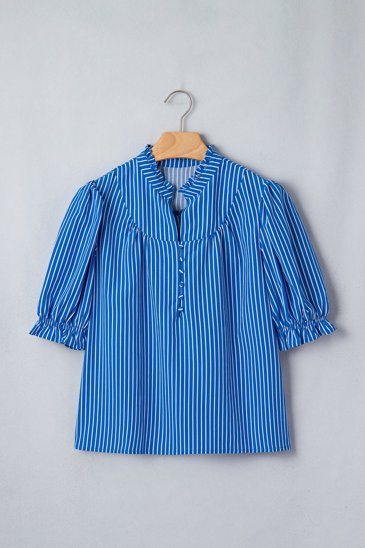 Blusa de manga corta abullonada con volantes y rayas azules, con botones en la parte delantera.