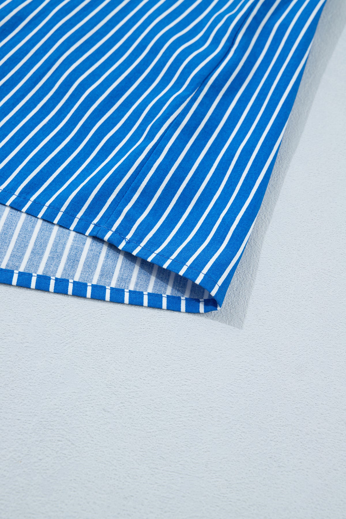 Blusa de manga corta abullonada con volantes y rayas azules, con botones en la parte delantera.