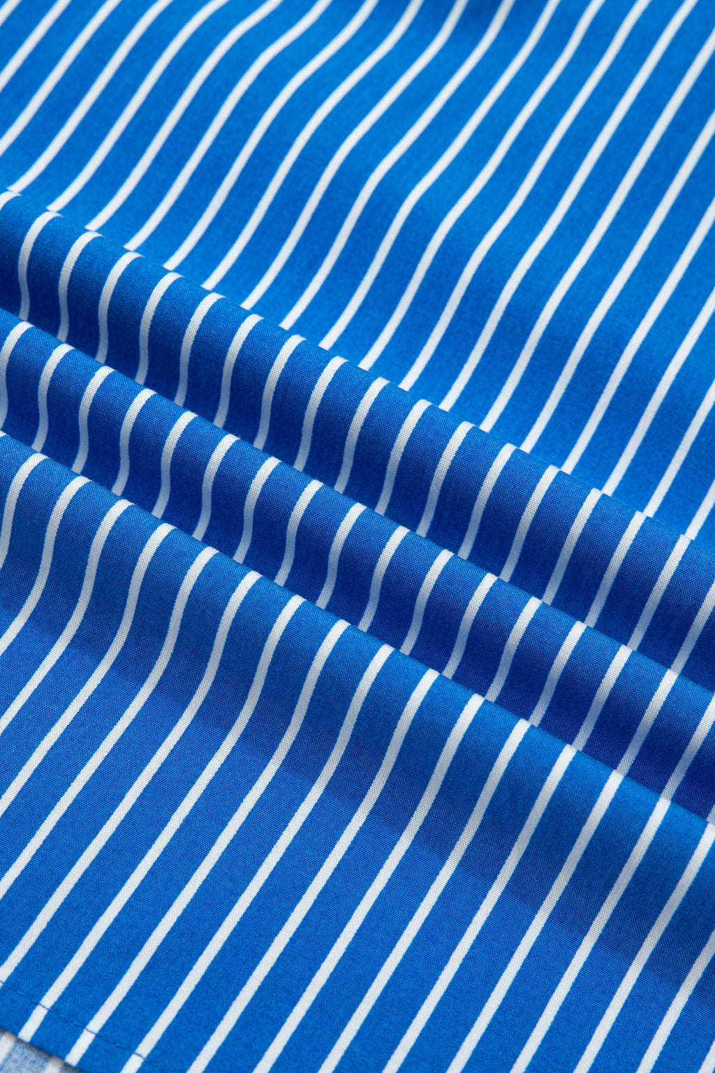 Blusa de manga corta abullonada con volantes y rayas azules, con botones en la parte delantera.