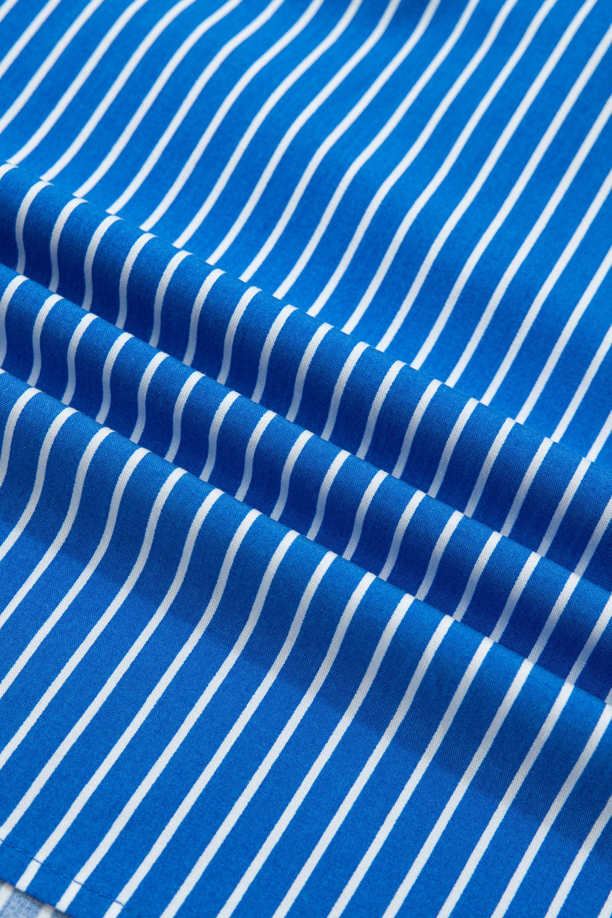 Blusa de manga corta abullonada con volantes y rayas azules, con botones en la parte delantera.