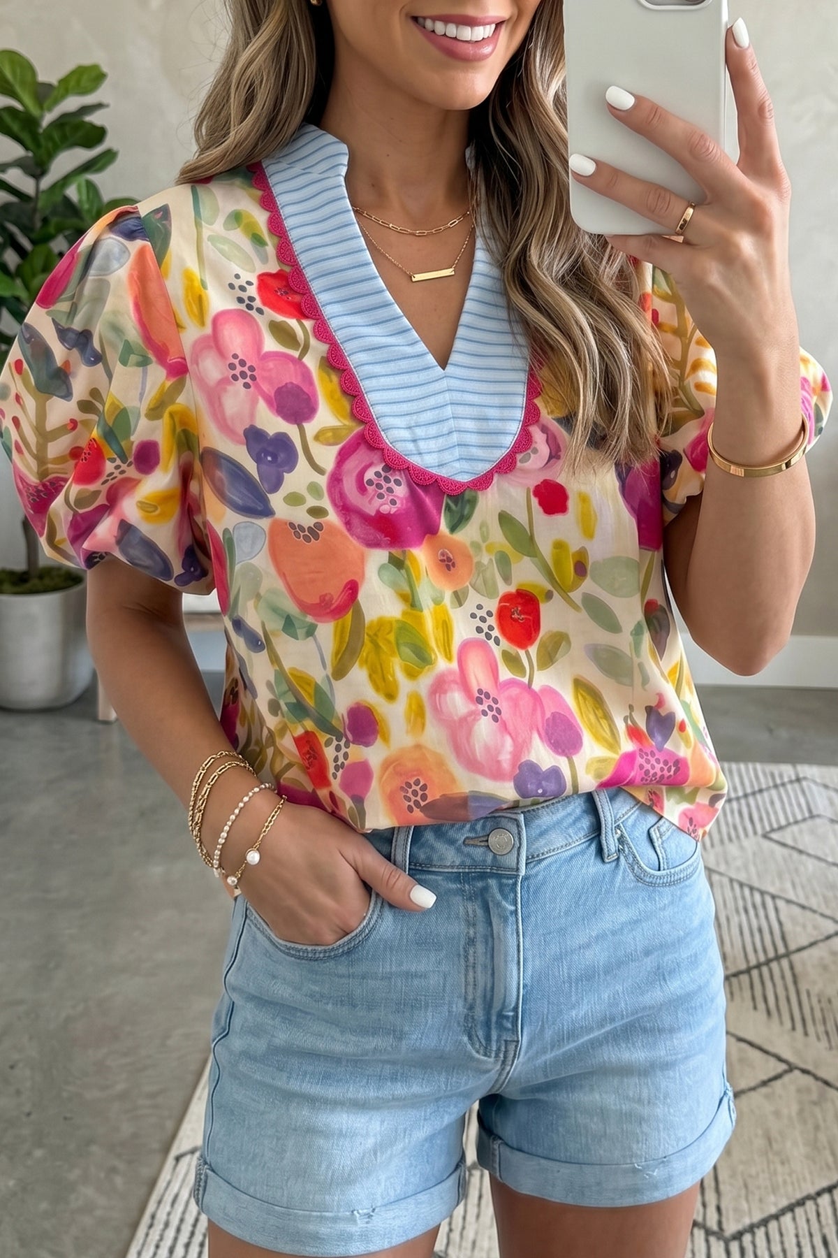Blusa de algodón con cuello en V y mangas cortas abullonadas con estampado floral de rosas.