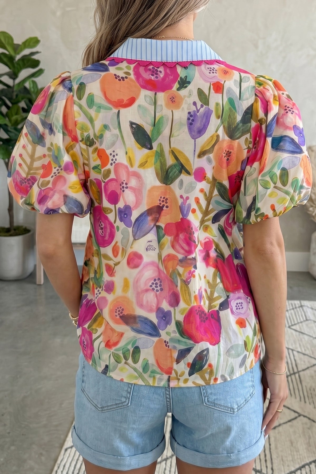 Blusa de algodón con cuello en V y mangas cortas abullonadas con estampado floral de rosas.