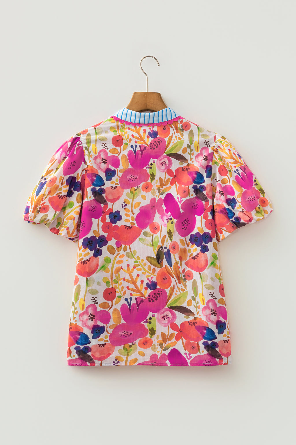 Blusa de algodón con cuello en V y mangas cortas abullonadas con estampado floral de rosas.