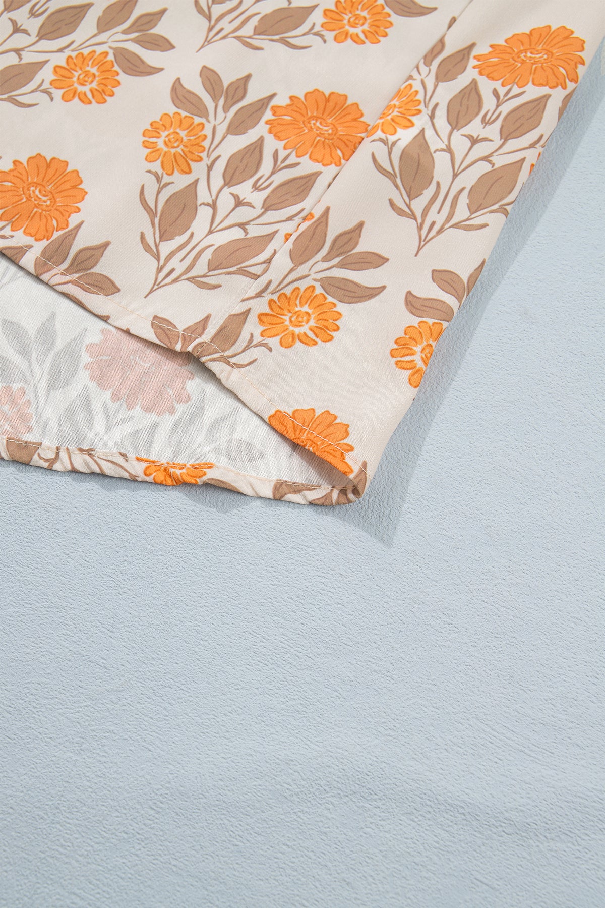 Blusa de manga larga con cuello en V y estampado floral naranja con detalles en contraste.