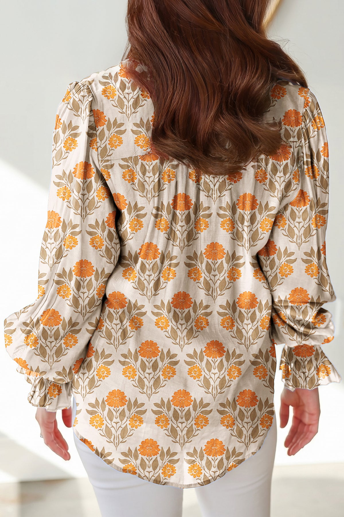 Blusa de manga larga con cuello en V y estampado floral naranja con detalles en contraste.