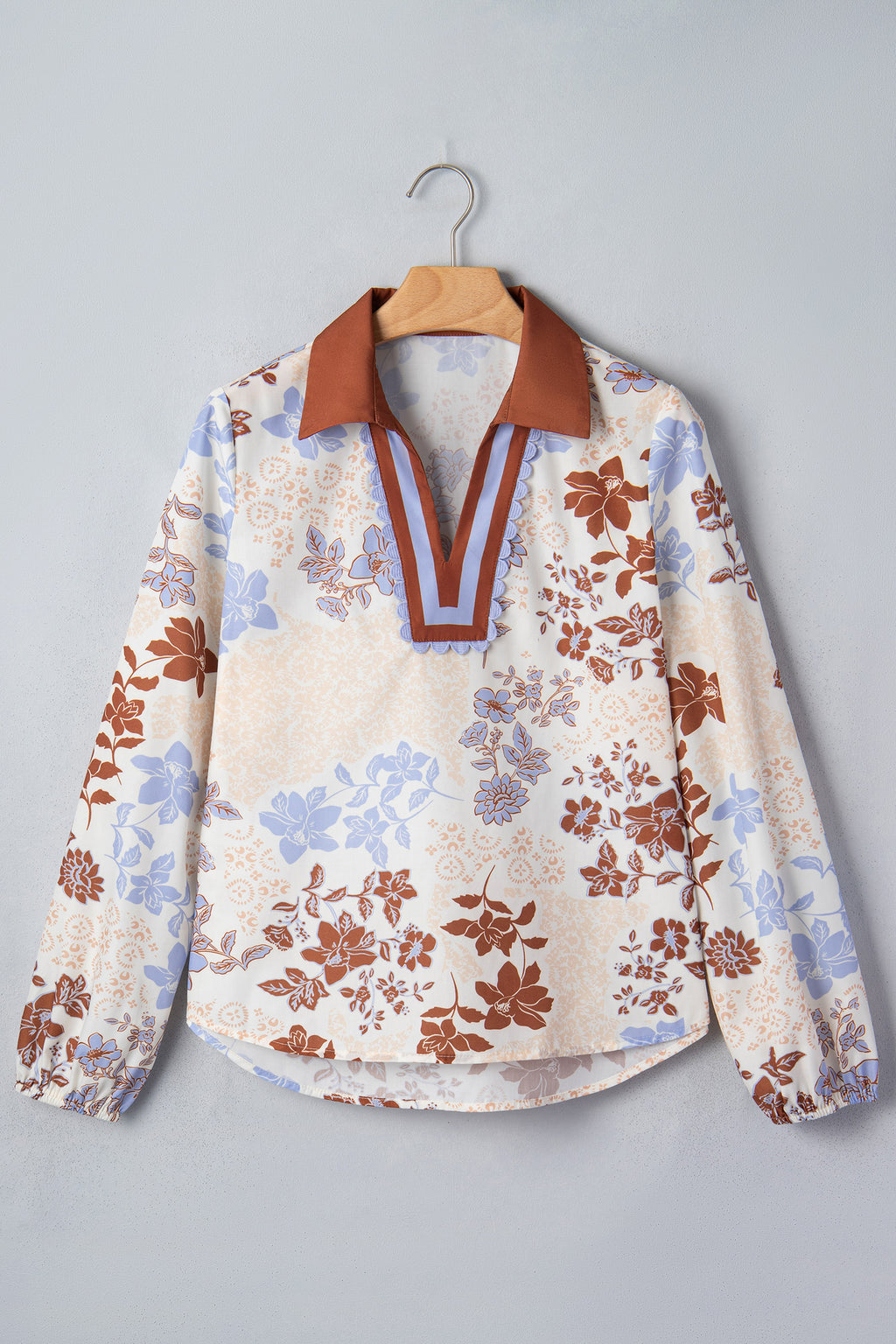 Blusa blanca de manga larga con cuello en V y bloques de color con estampado floral.