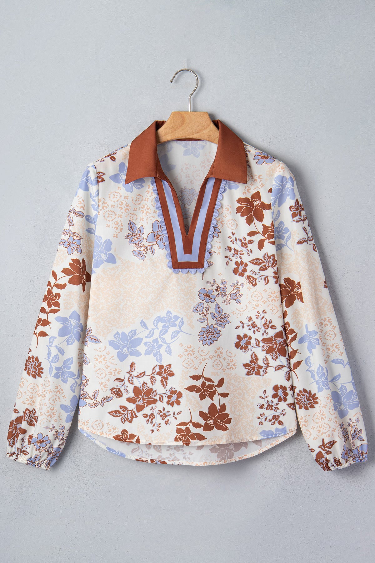 Blusa blanca de manga larga con cuello en V y bloques de color con estampado floral.