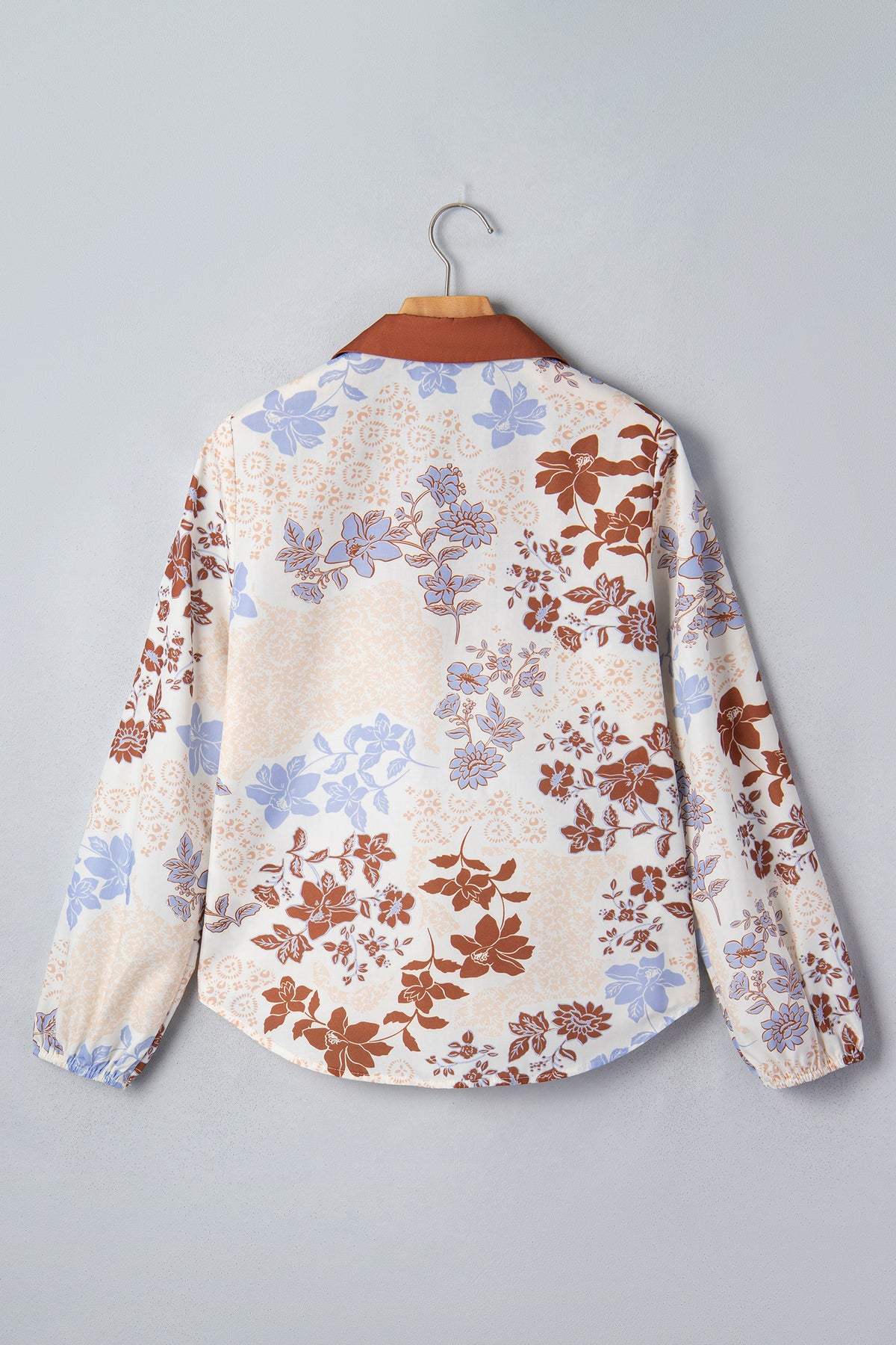 Blusa blanca de manga larga con cuello en V y bloques de color con estampado floral.