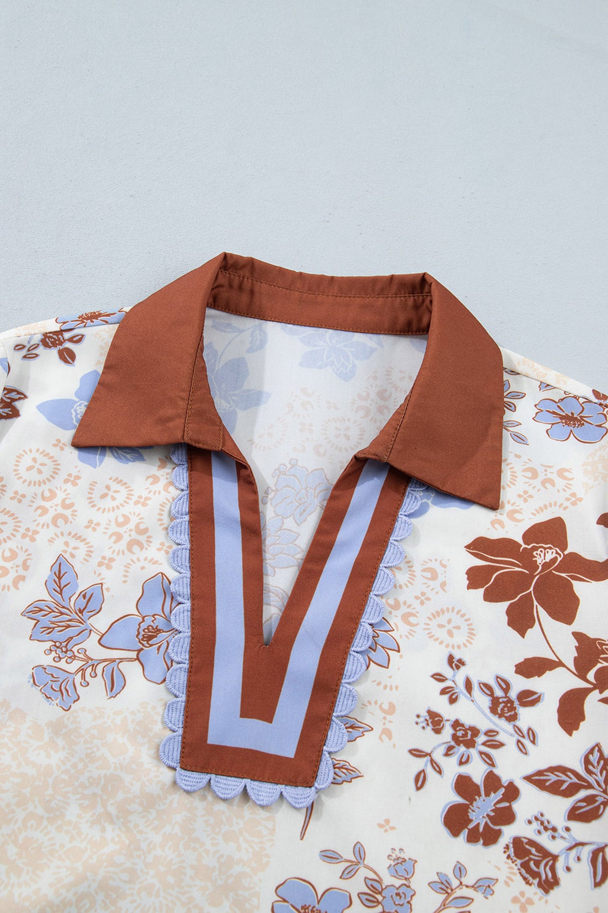 Blusa blanca de manga larga con cuello en V y bloques de color con estampado floral.