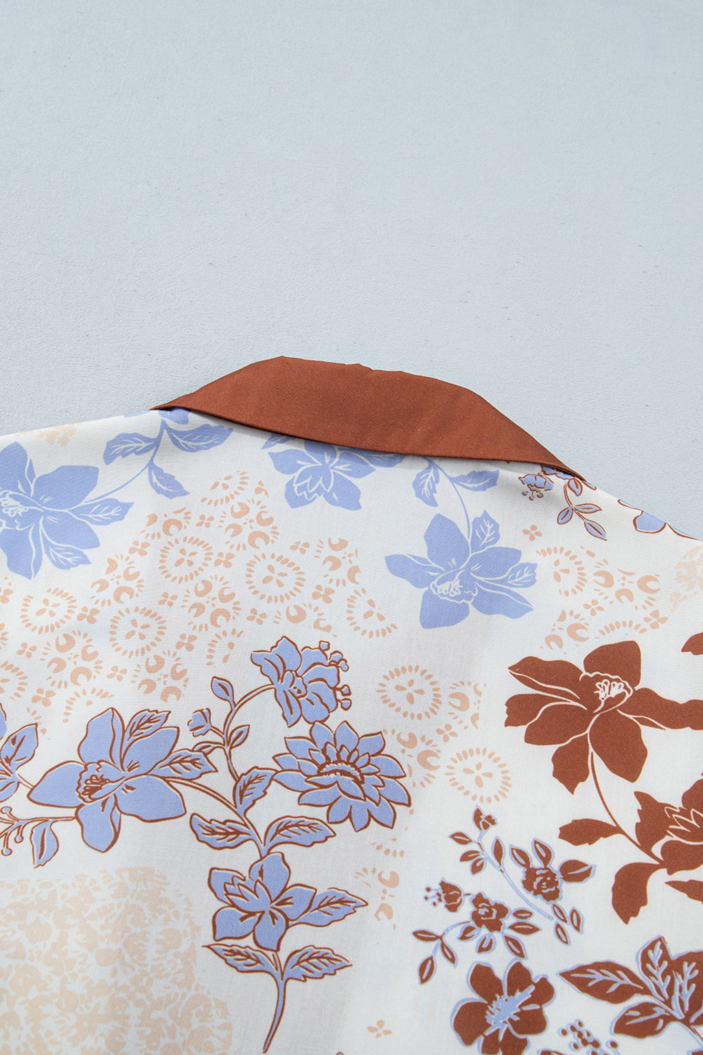 Blusa blanca de manga larga con cuello en V y bloques de color con estampado floral.