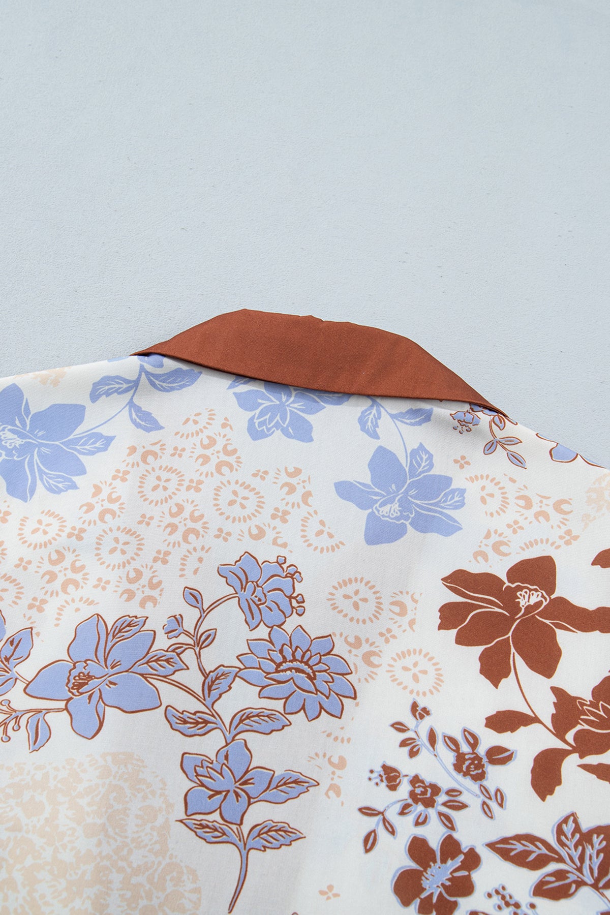 Blusa blanca de manga larga con cuello en V y bloques de color con estampado floral.