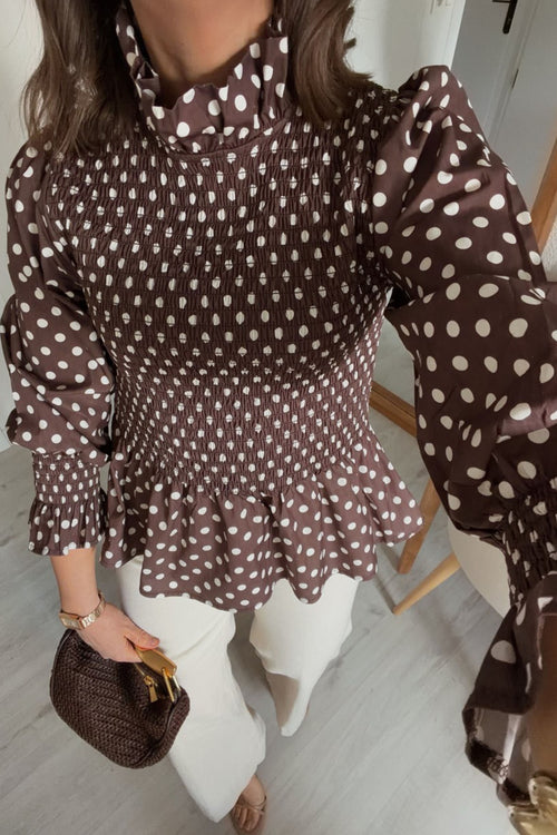 Blusa marrón de cuello alto con volantes y bajo fruncido con volantes y lunares.
