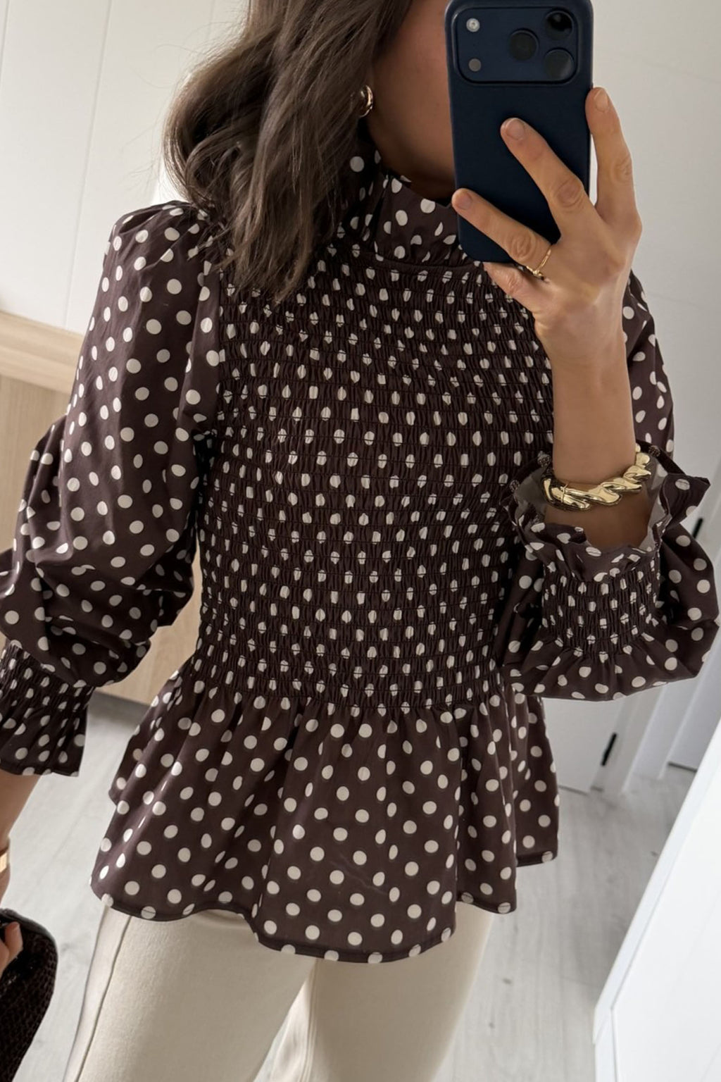 Blusa marrón de cuello alto con volantes y bajo fruncido con volantes y lunares.