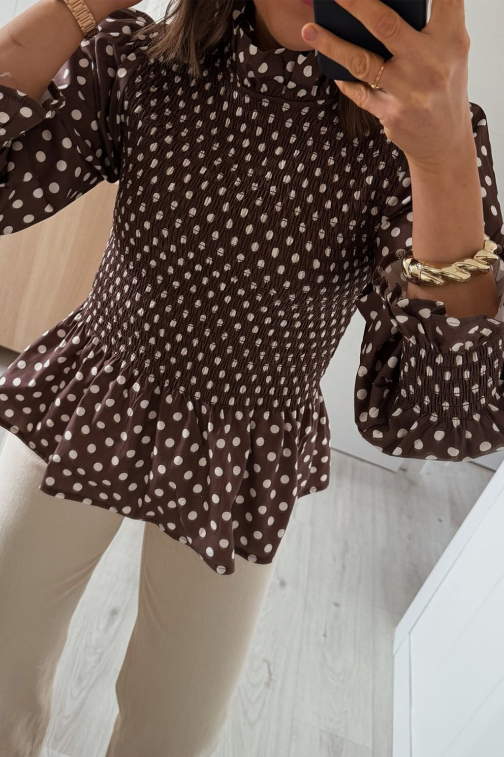 Blusa marrón de cuello alto con volantes y bajo fruncido con volantes y lunares.