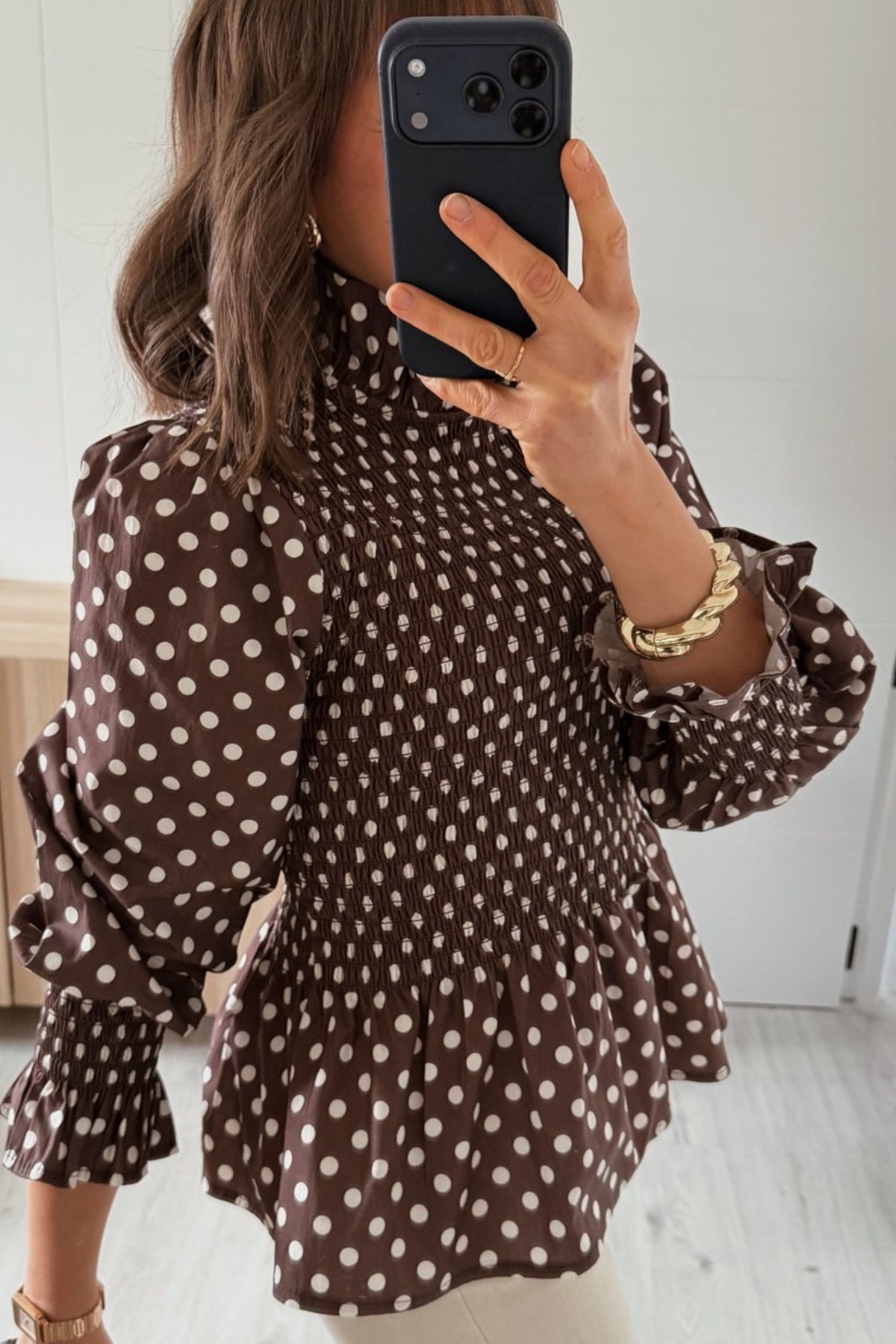 Blusa marrón de cuello alto con volantes y bajo fruncido con volantes y lunares.
