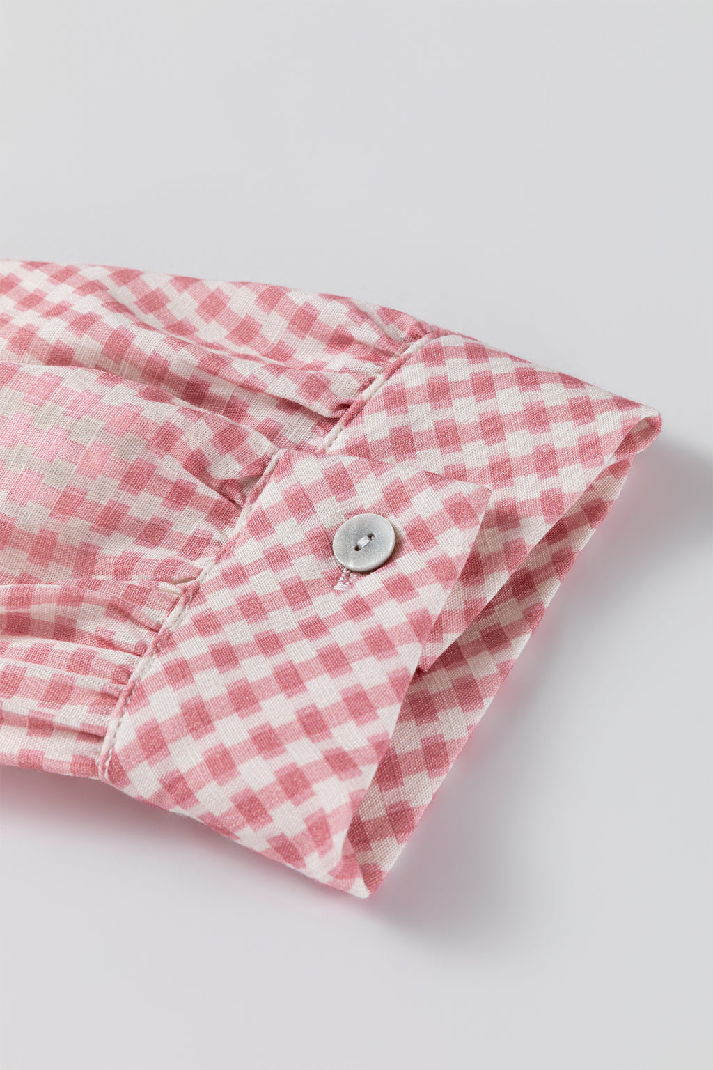 Camisa abotonada de manga corta con volantes y bajo a cuadros rosas