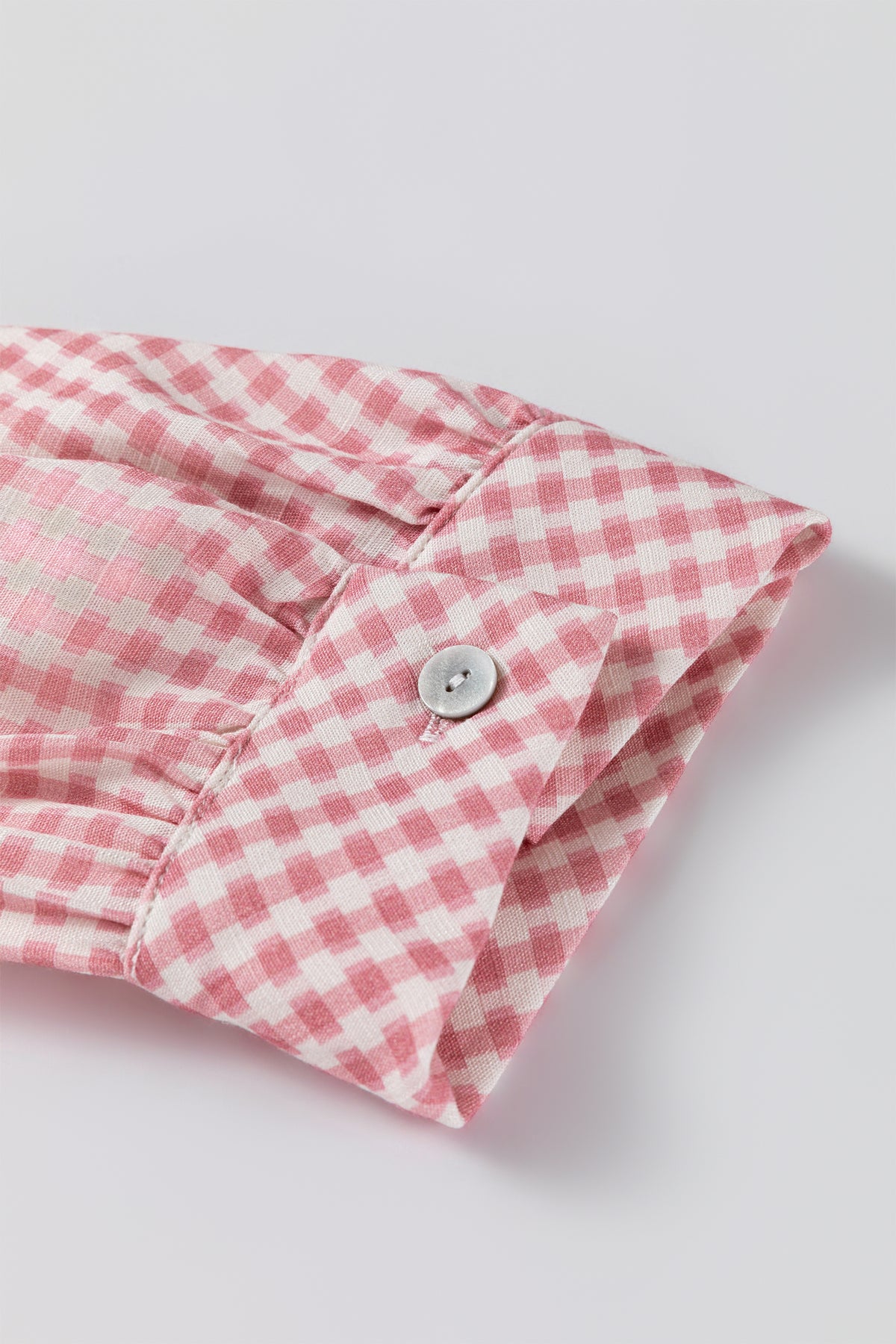 Camisa abotonada de manga corta con volantes y bajo a cuadros rosas