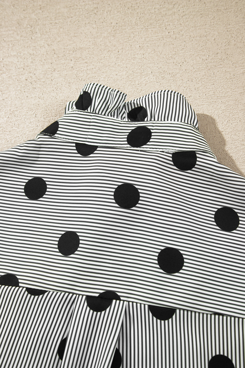 Camisa de manga tres cuartos con cuello alto, cuello alto y estampado de rayas y lunares rojos intensos.