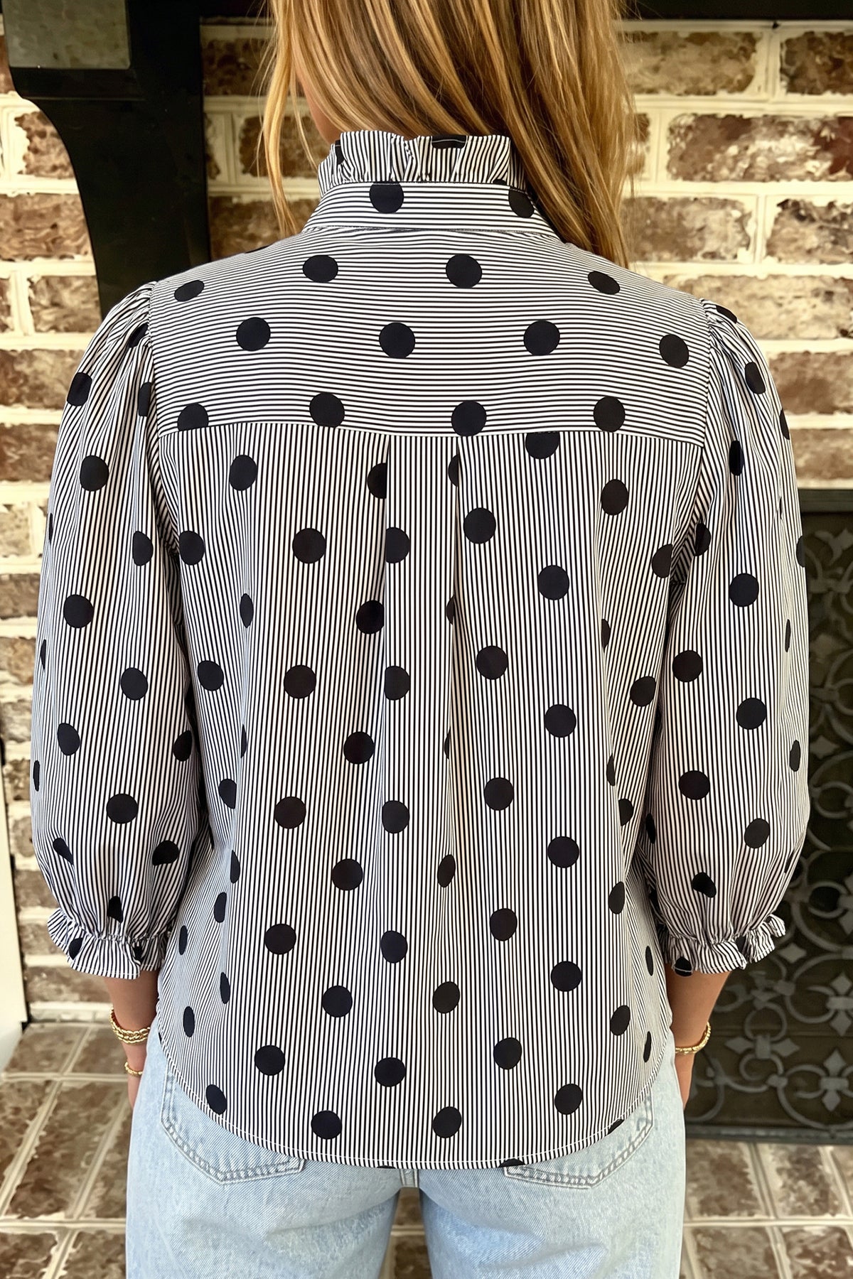 Camisa de manga tres cuartos con cuello alto, cuello alto y estampado de rayas y lunares rojos intensos.